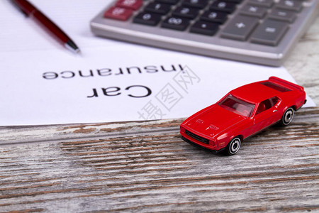 汽车保险会计概念红色玩具车加计算器和图片