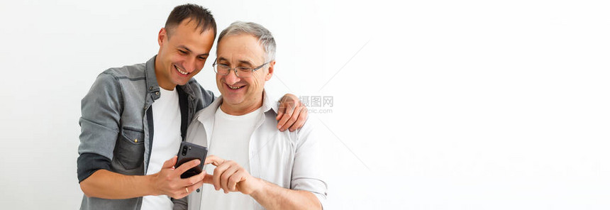 快乐的两代男家庭老父亲拥抱年轻成年儿子图片