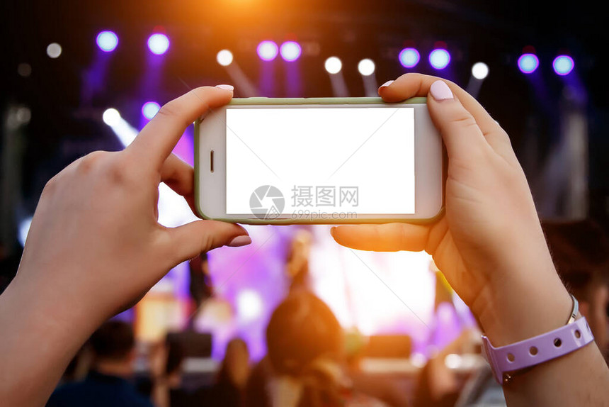 在音乐会上为社交网络直播使用智能手机相您的内容的白色智能图片