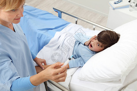 给躺在病房床上的病童注射后护士检查注图片
