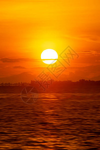 大太阳和日落天空在湖面的垂直图像图片