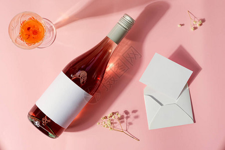 玫瑰酒瓶葡萄酒杯和情书的贺卡图片