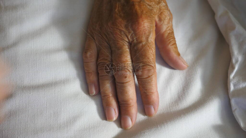 孙女接过并轻抚摸躺在病床医院里生病的成熟奶皱巴的手臂女孩在诊所安慰她祖母的手关心和爱的图片