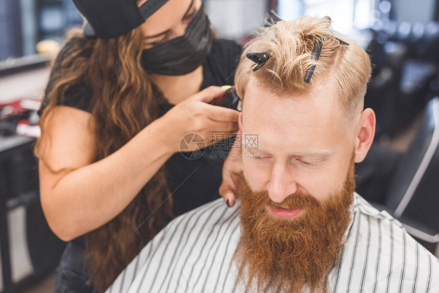理发店的男士理发头发护理发师和客户戴着防面具图片