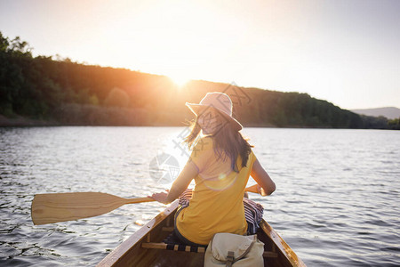 坐在日落湖上的木独舟中微图片