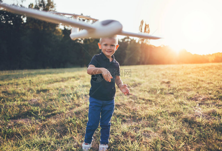 男孩喜欢玩飞机模型微笑的男孩扔飞机图片