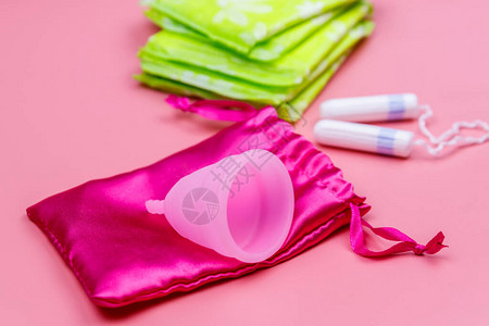 粉红色背景的卫生巾卫生棉条和月经杯关键日子月经女图片
