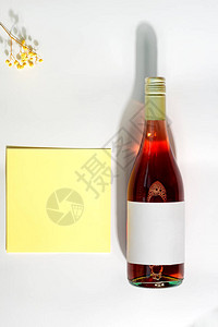 祝贺明信片与一瓶玫瑰酒温柔的天然花和信卡在浅灰色背景的信封中图片