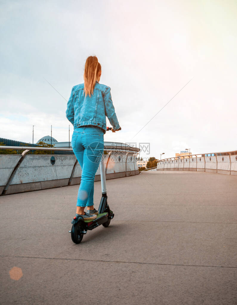 城市滑板车使用从女商人那里踢电动自行车欧洲市中心的图片