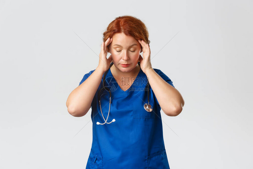 疲惫而头晕的红发中年医务人员图片