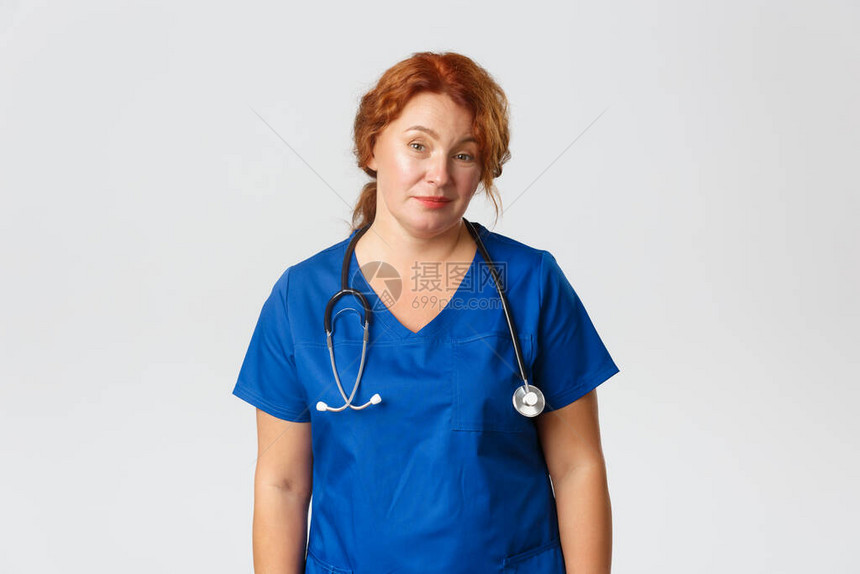 轻描淡写且未受滥用的红发女医务工作者医生嘲弄并沮丧地看着不情愿图片