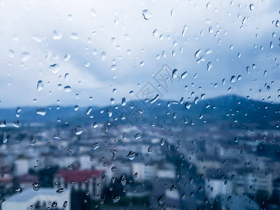 有线车窗上的雨模糊的城市和图片