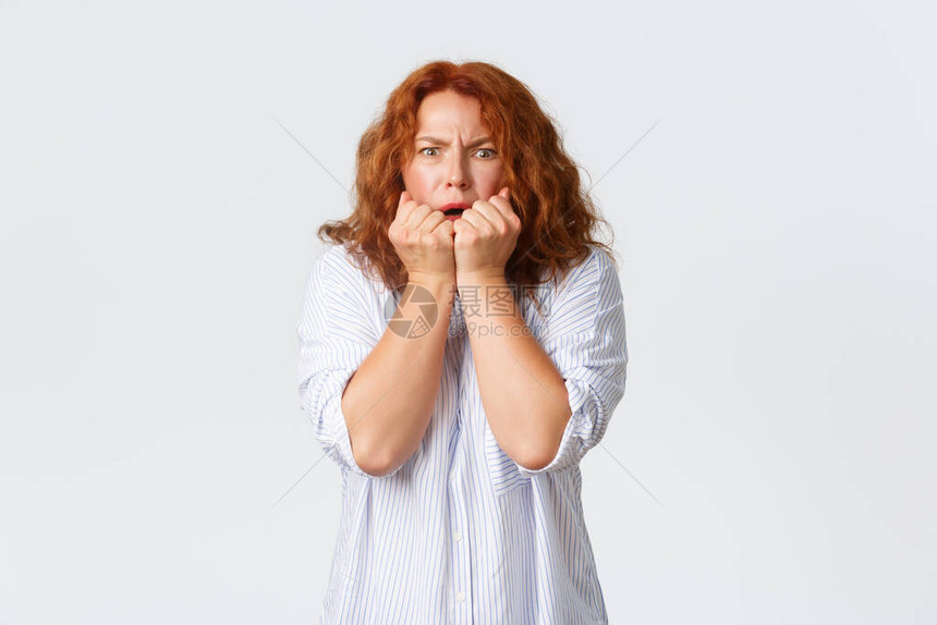 害怕和惊恐的白种人中年红发女人手牵捂着嘴图片