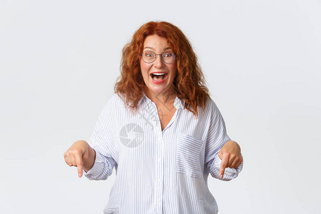 印象深刻和惊讶的中年红发女对可怕的消息做出反应图片