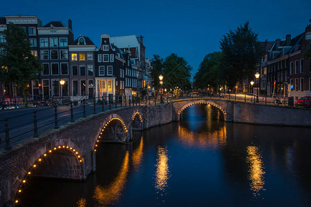 城市的灯光反射在晚上的运河水上荷图片