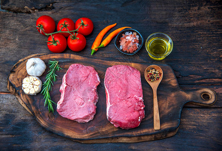 厨房木板桌背景上的生肉牛排有机新鲜配料图片