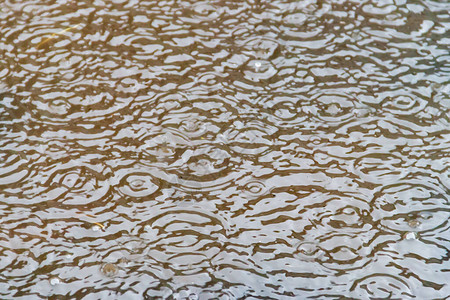 在倾盆大雨中溅起雨滴的水坑图片