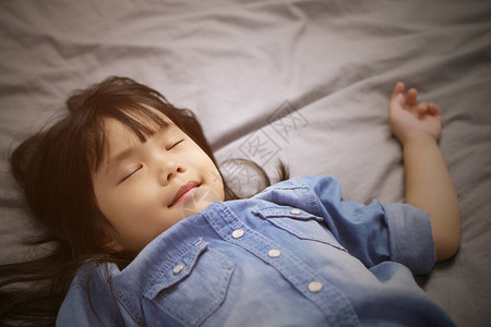 亚裔儿童可爱或小女孩身穿牛仔裤睡着和甜蜜的梦想图片