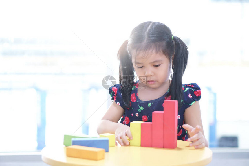 亚洲儿童或小女孩想玩彩色木块玩具图片