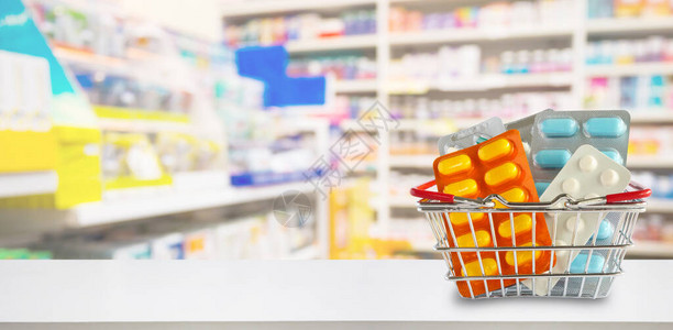 药店货架模糊背景购物篮中的药丸包装图片