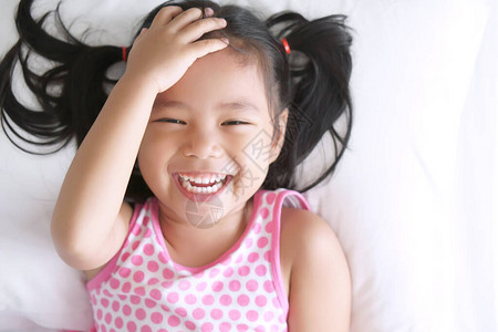 亚洲儿童快乐或小女孩睁开眼睛睡觉图片