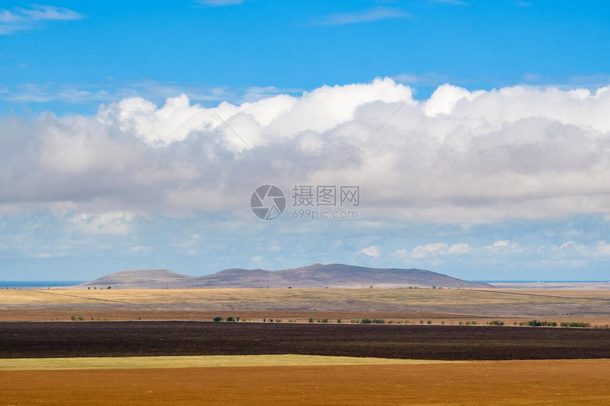 地貌山景和巨大的白云在前景中图片