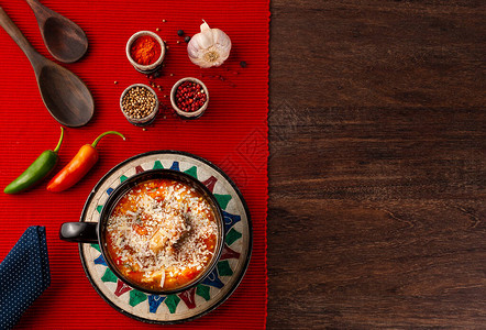 上面放着磨碎的奶酪大蒜红辣椒和青椒木勺和带餐巾的辣椒种子图片