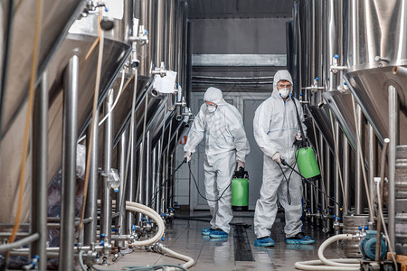 隔离和工厂程在啤酒厂内消毒的哈兹马特西装工图片