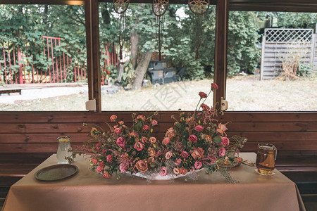 在木屋里布置粉红色花朵的婚礼桌图片