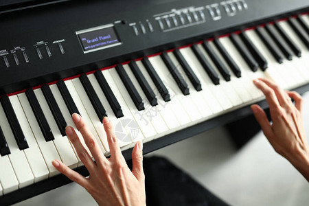特写女手躺在数码钢琴的键上隔离期间现场音乐节图片
