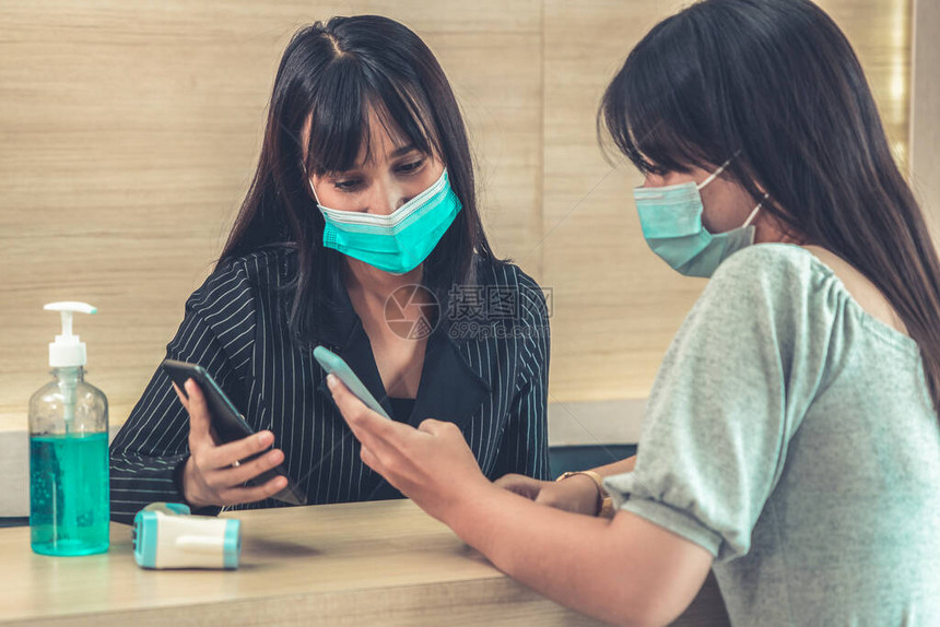 接待员和客人在办公室或医院交谈时在前台戴口罩Covid19和Coronavirus感染保护和图片