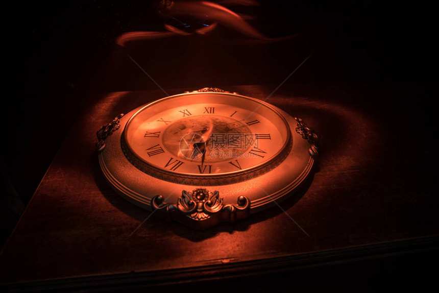 大老式圆钟在木制桌上图片