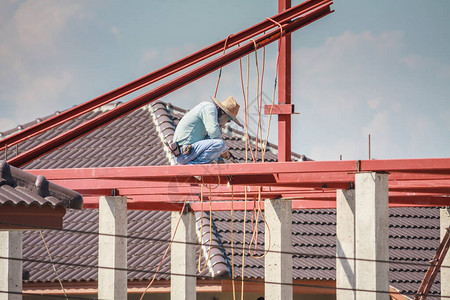 建筑焊工在有云天的建筑工地安装房屋顶钢架结构图片