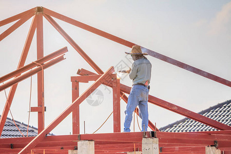 建筑焊工在有云天的建筑工地安装房屋顶钢架结构图片