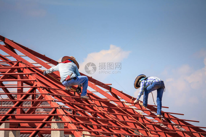 建筑焊工在有云天的建筑工地安装房屋顶钢架结构图片