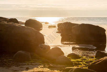 在海滩的岩石上的日落图片