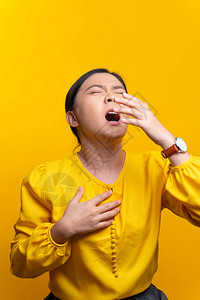 亚洲妇女喉咙痛咳嗽打喷嚏在黄色背图片