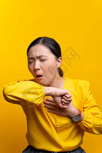 亚洲妇女喉咙痛咳嗽打喷嚏在黄色背图片