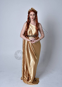 穿着长的希腊花圈和金花环的红发女孩全长肖像背景图片