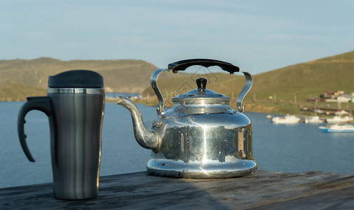 湖底的旧金属茶壶和旅行杯图片