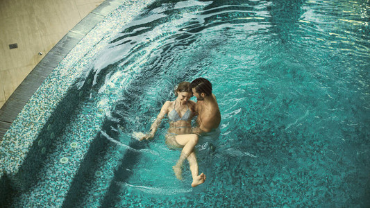 幸福的夫妻在蜜月时享受游泳池图片