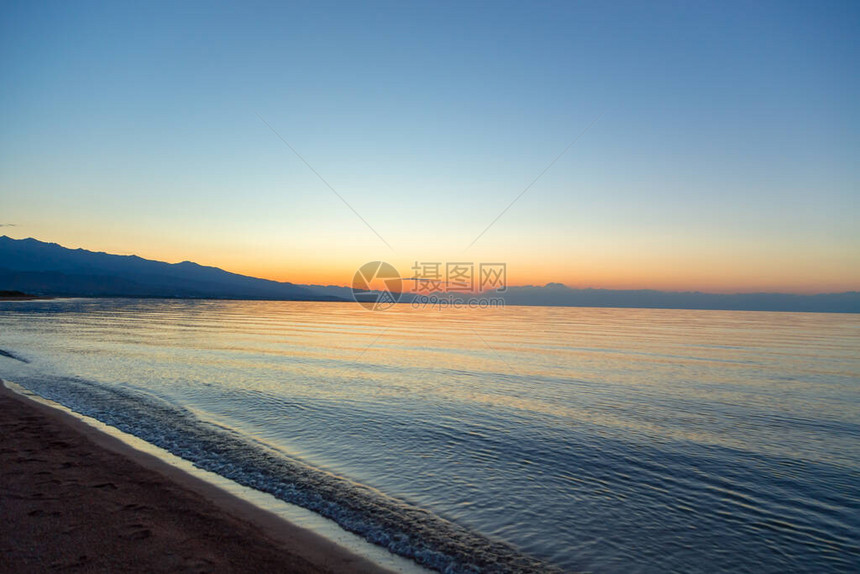 海上太阳的黎明山后初升的太阳图片