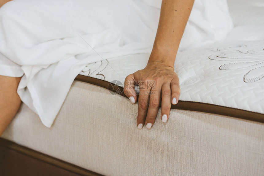 女人在家具店测试床垫填充床垫的概图片