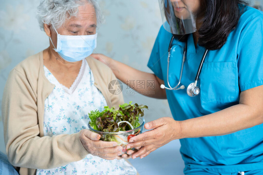 亚洲老年或老年妇人病在医院病床上坐着饿肚子吃早餐蔬菜健康食品图片