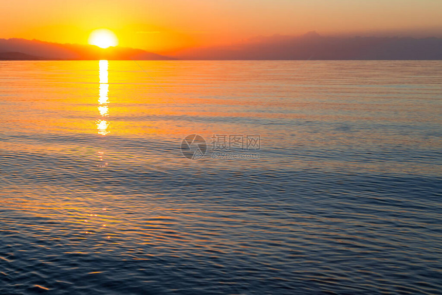 海上太阳的黎明山后初升的太阳图片