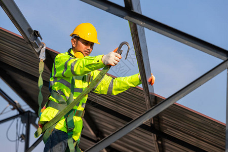 亚洲屋顶建筑工人穿着安全高度设备安装屋顶框架图片