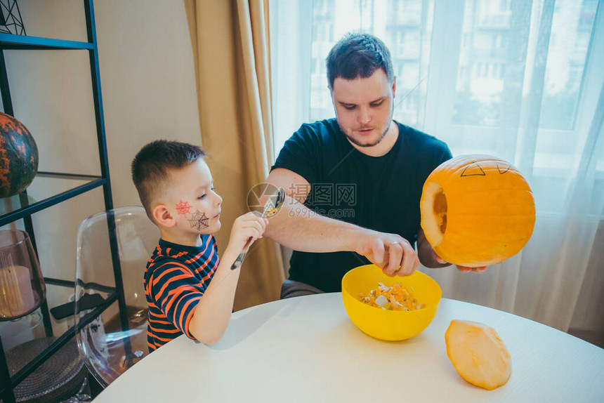 年幼父亲和小孩的儿子在万圣节上图片