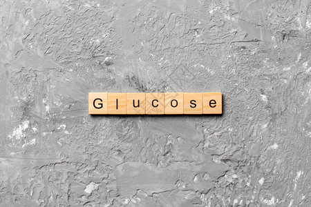 GLUCOSE字词写在木块上水泥桌上的GLUCOSE文字写在你的图片