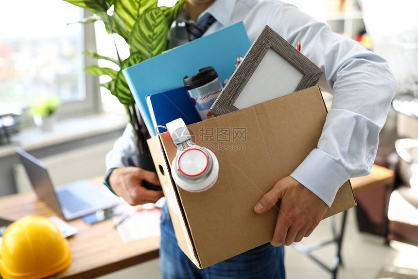 一个男人带着一箱个人物品去一个新的工作场所穿衬衫的人拿着一朵花和一图片