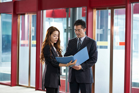 在公司大厅里站着和说话的亚洲男女商图片